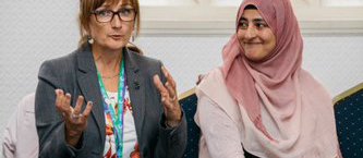 Two women speaking during community meeting