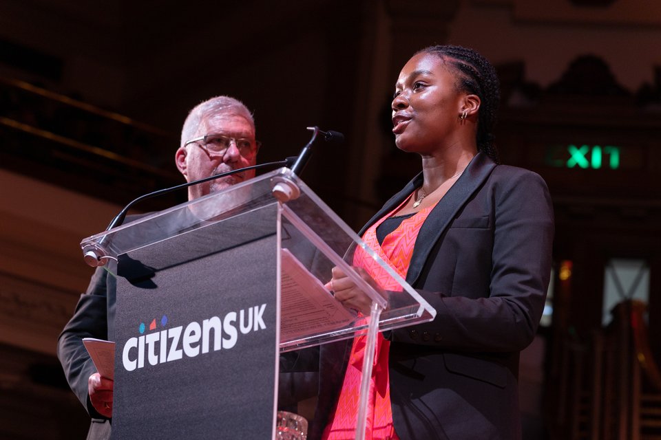 A young Citizens UK leader is speaking on stage.