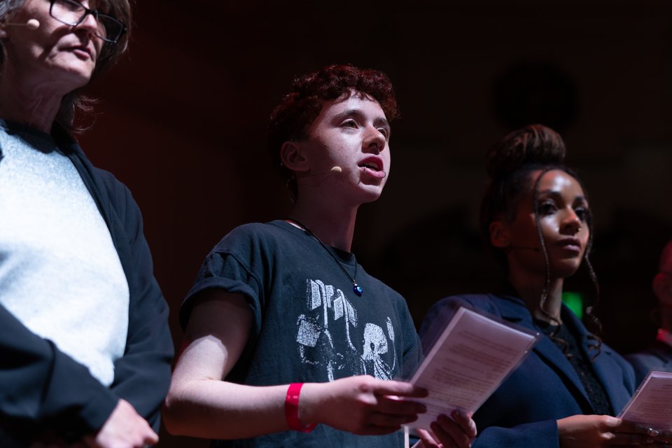 A young Citizens UK leader shares their testimony on a stage.