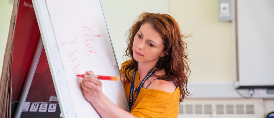 Person writing on whiteboard