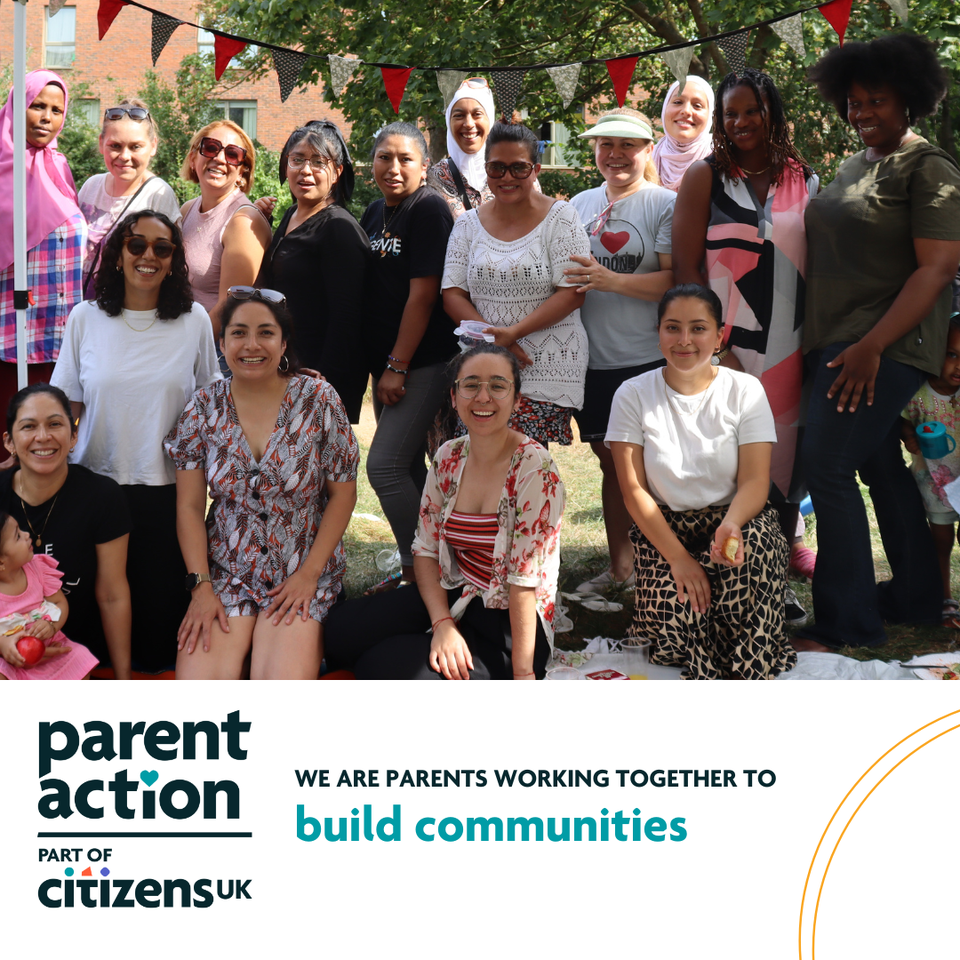 A group of smiling parents with a banner reading 'we are parents working together to build communities'