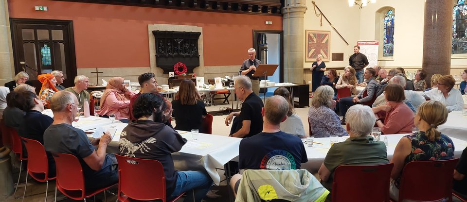A photograph of the participants listening to Angus Ritchie speak