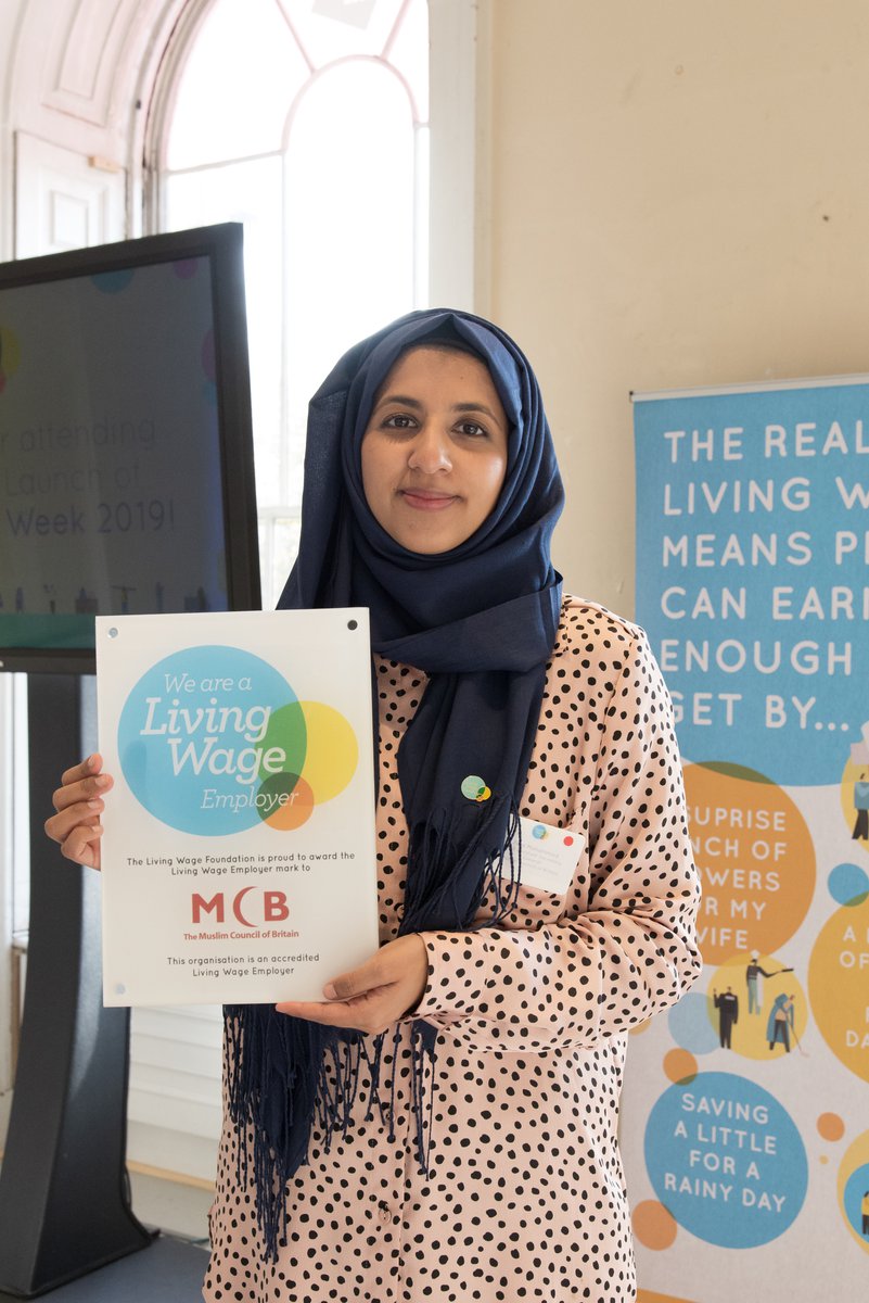 Woman holding up Living Wage poster
