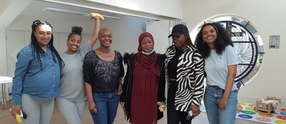 Women from Black Maternal Voices project pose together smiling and waving