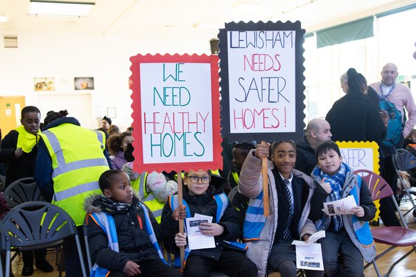 Lewisham pupils holding signs calling for safe and healthy homes