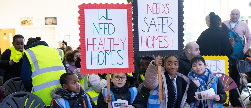 Lewisham pupils holding signs calling for safe and healthy homes