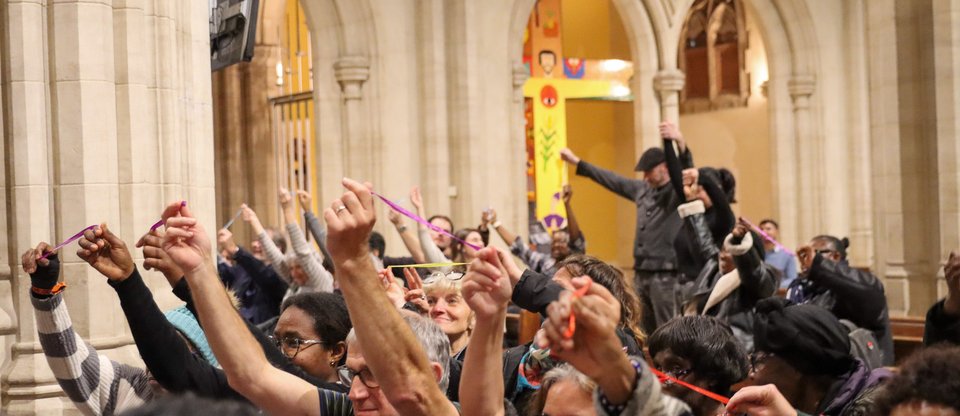 Community leaders are sitting in the Cathedral hall holding up pieces of string at the South London Citizens assembly