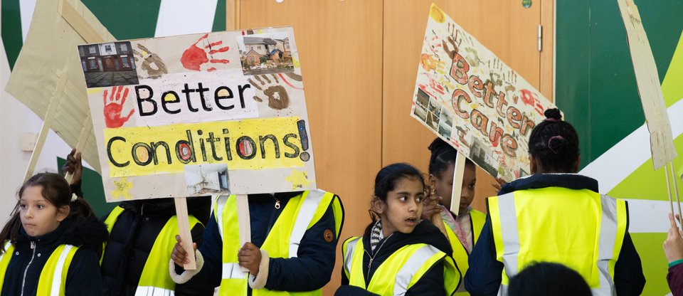 Young students at a Lewisham Citizens housing action holding placards