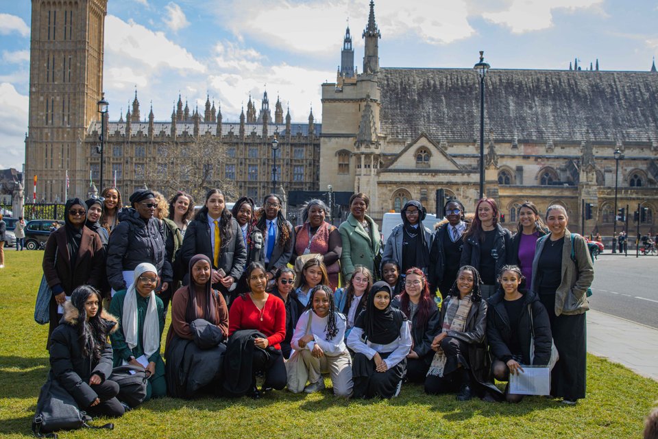 a bright picture of a group of citizens uk leaders stand in parliament square with the houses of parliament behind them