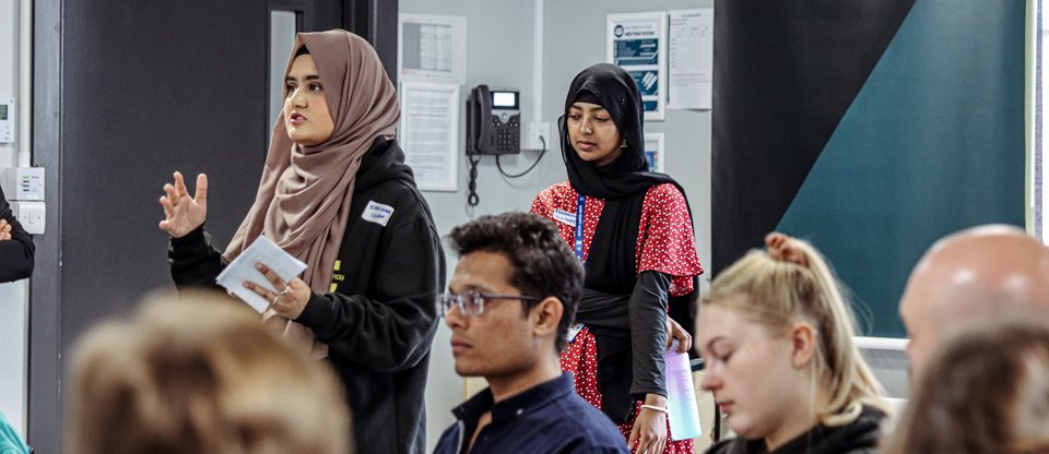 Young person from a Students Union standing and speaking to room of people