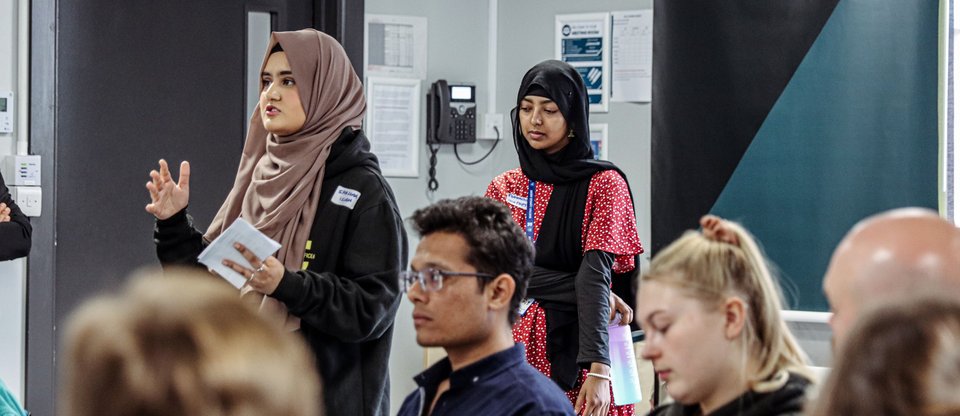 Young person from a Students Union standing and speaking to room of people