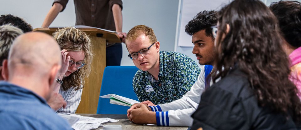 People sat around a table during leadership training discussing together