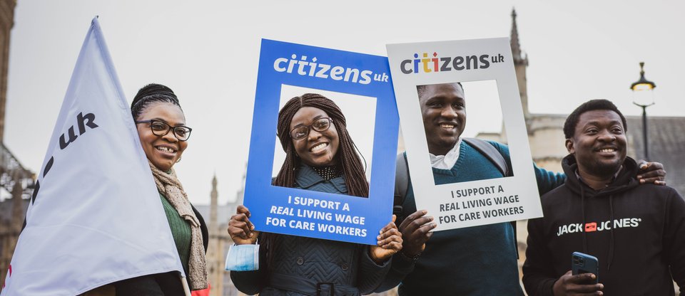 Citizens UK leaders, action in Parliament Square, holding signs that read I support a real living wage for care workers, March 2021