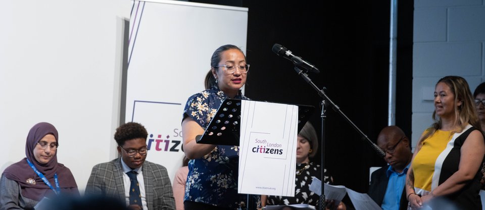 Woman speaking at podium during south london listens assembly