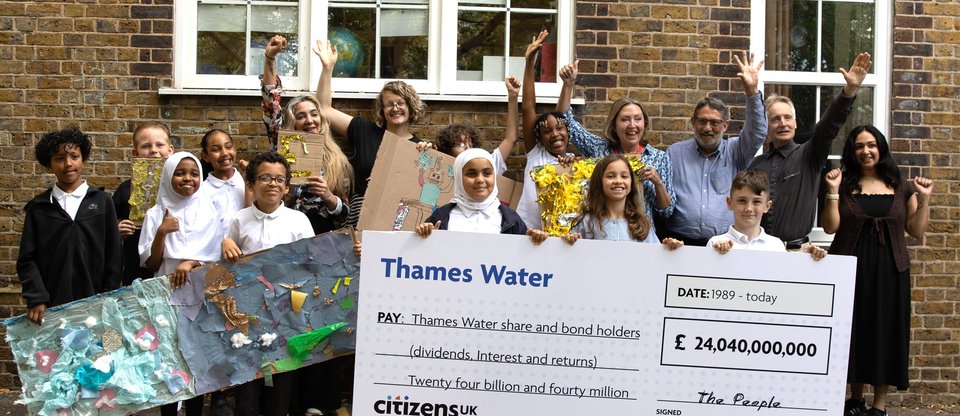 Adults and young people holding a giant cheque for £24 billion and collage artworks