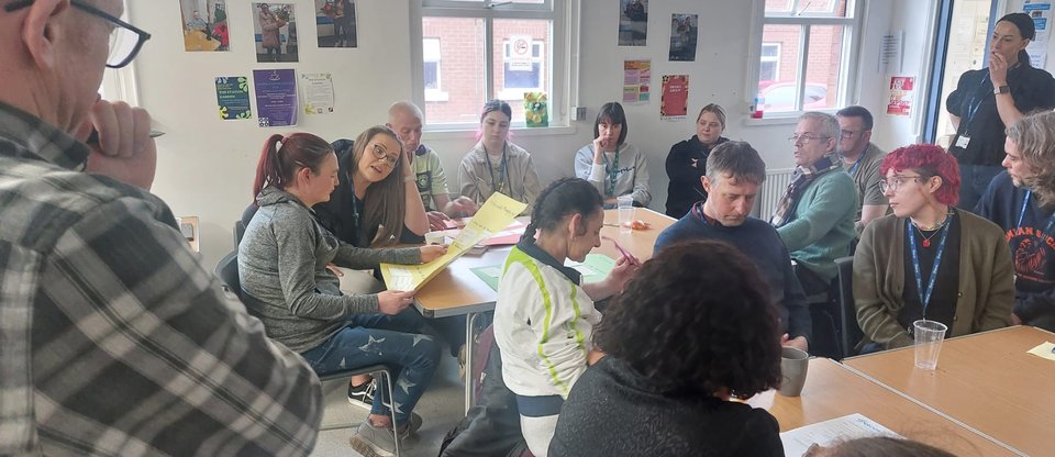 Petrus Community members sat at tables during a workshop on Universal Credit