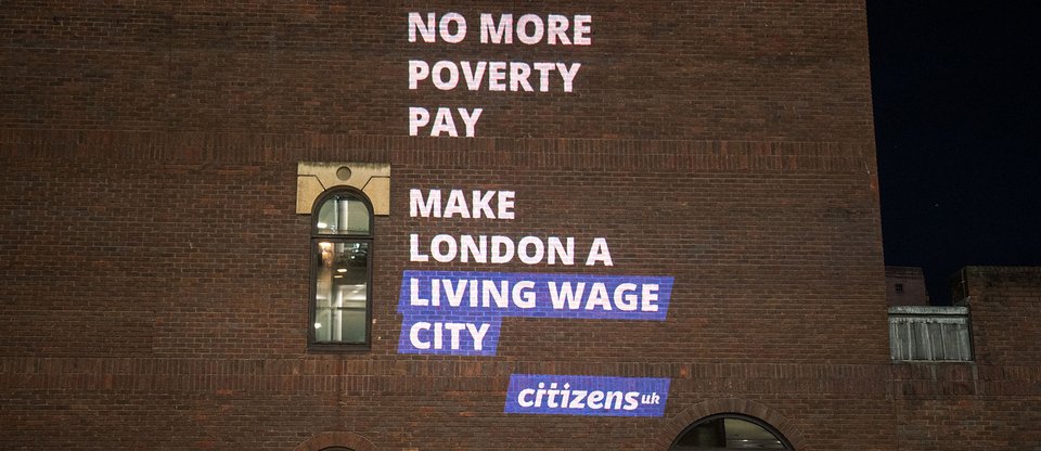 Projection near St Paul's saying 'No more poverty pay, make London a living wage city'