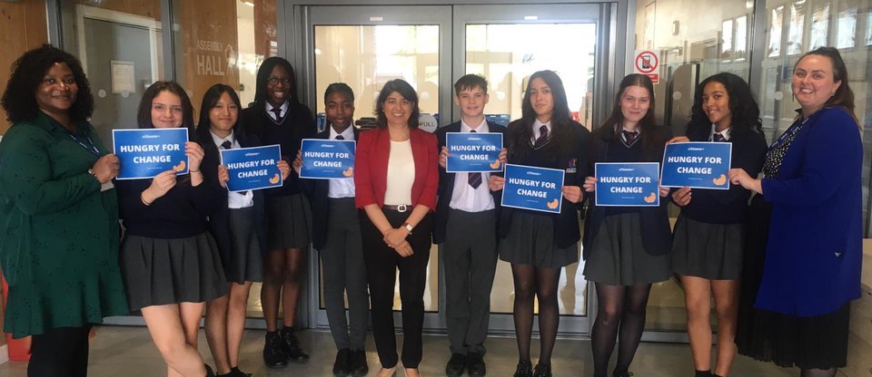 Students are holding small banners that read 'Hungry for change' with an MP.