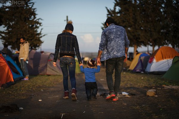 Refugee family holding hands at camp site