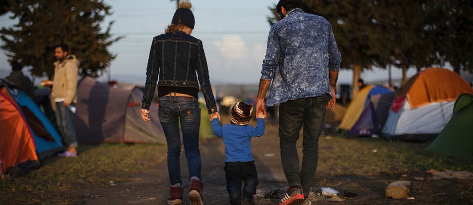 Refugee family holding hands at camp site