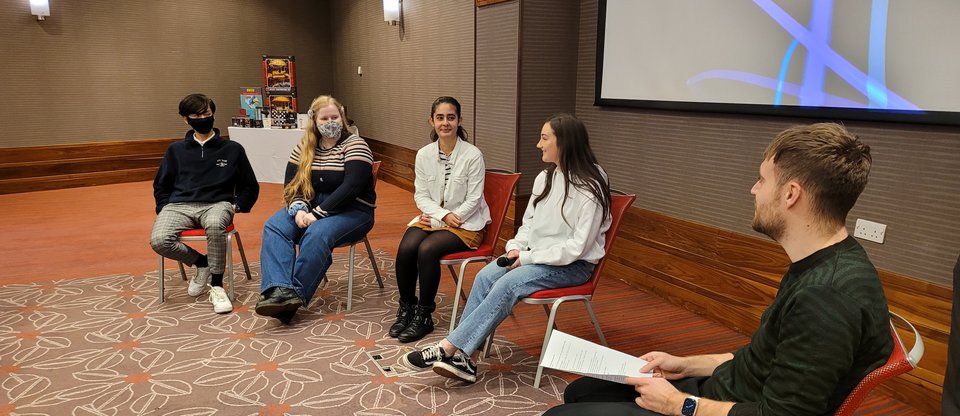 Five young people sit in a hall discussing the campaign for school-based counselling