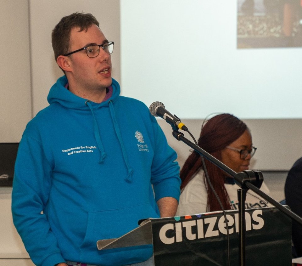 A male student is speaking at a Citizens UK event