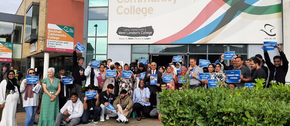 Young people and community leaders are holding banners that read 'hungry for change' with an MP