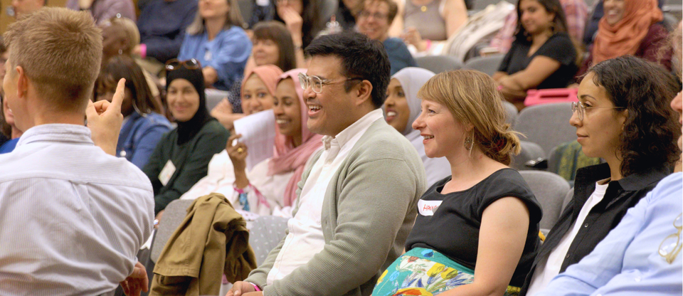 Citizens UK staff laughing in a hall at an away day