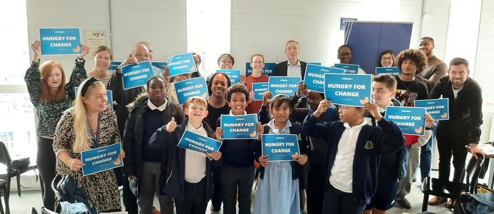 A group of young pupils are holding 'Hungry for change' banners