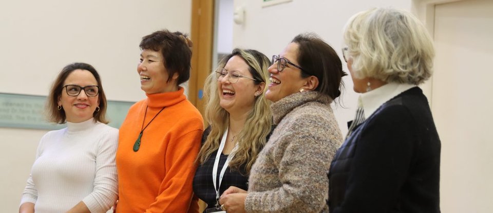 People standing next to each other in a line laughing during living wage workshop