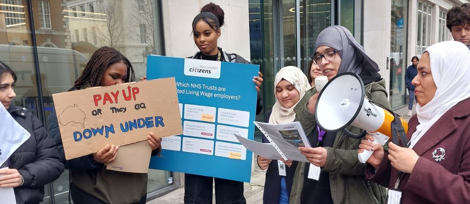 A group of students hold banners and megaphones during a protest, asking for health and social care workers to be payed the real Living Wage in West London.