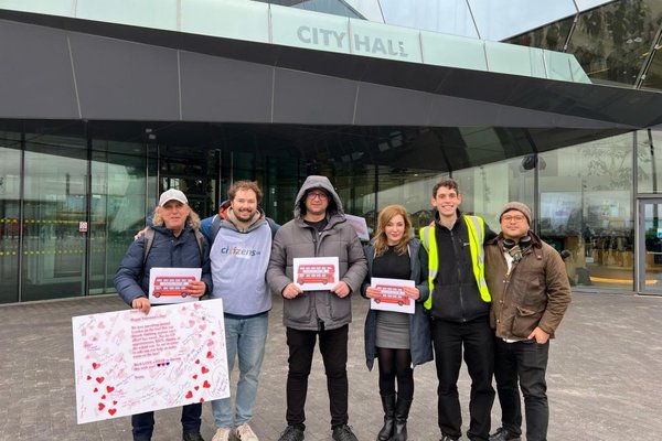 Six community leaders are holding Valentine's cards asking for free bus travel for asylum seekers.