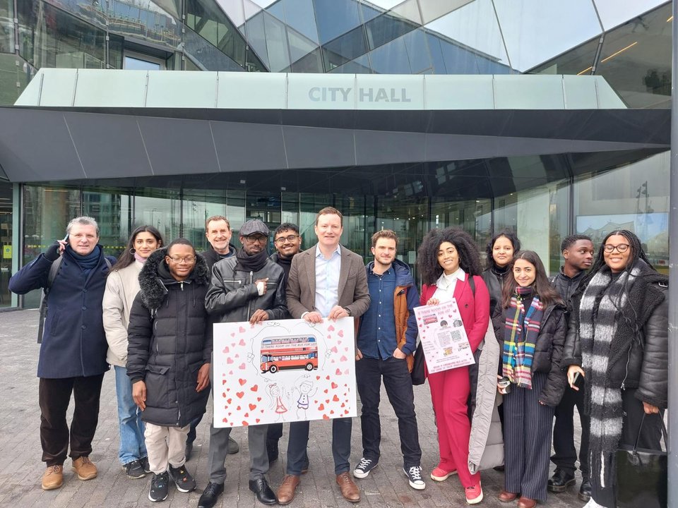 Transport Deputy Mayor Seb Dance and Citizens UK community leaders holding Valentine's Day cards for free bus travel for asylum seekers.