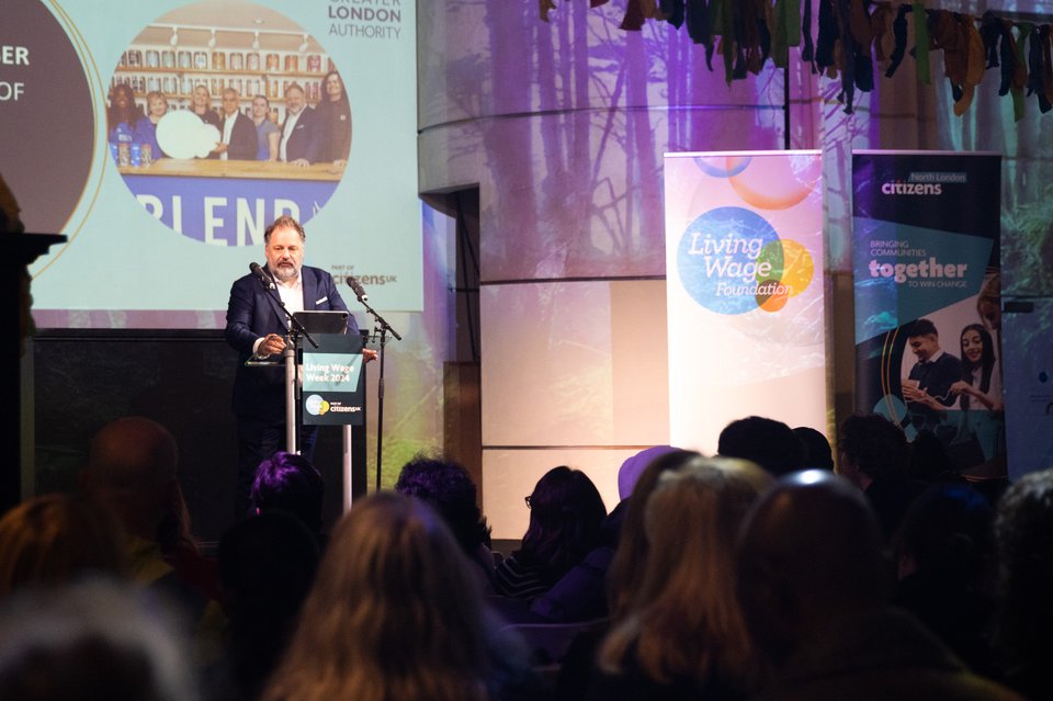 Howard Dawber, Deputy Mayor of London for Business and Growth, stands at a podium on stage giving a speech