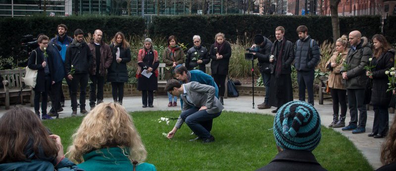 Two people dropping flowers at memorial - filmed