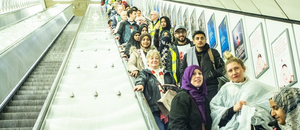 People standing on a metro escalator on the way to an action