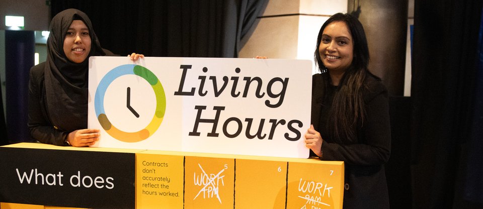 Two members of staff stand behind a large 3D puzzle, which says "Living hours: what does insecure work look like?"