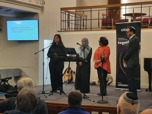 Four community leaders of different faiths speaking at a London Citizens event